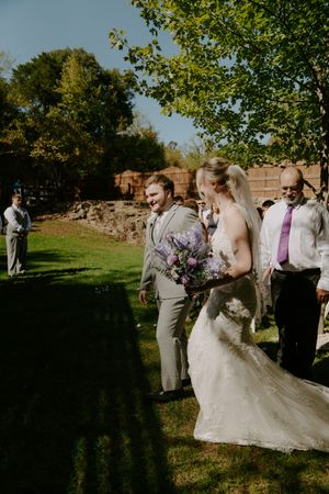 Wedding celebration taking place in a sunlit garden with guests watching the festivities.
