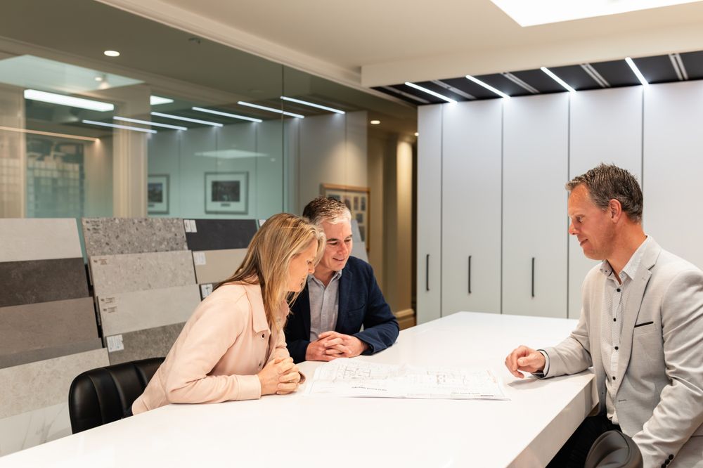 Business meeting in modern office conference room with people reviewing documents.