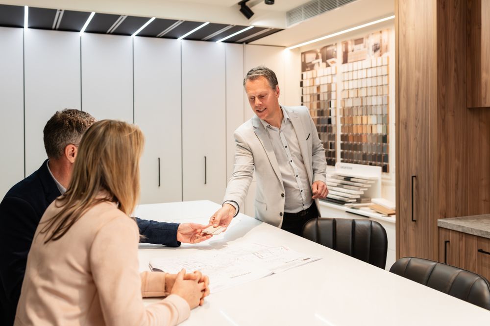 Interior design consultation showing material samples and finishes in office setting.