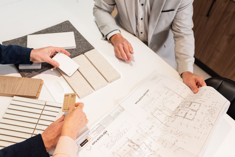 Close-up view of hands pointing at architectural blueprints during a design meeting.