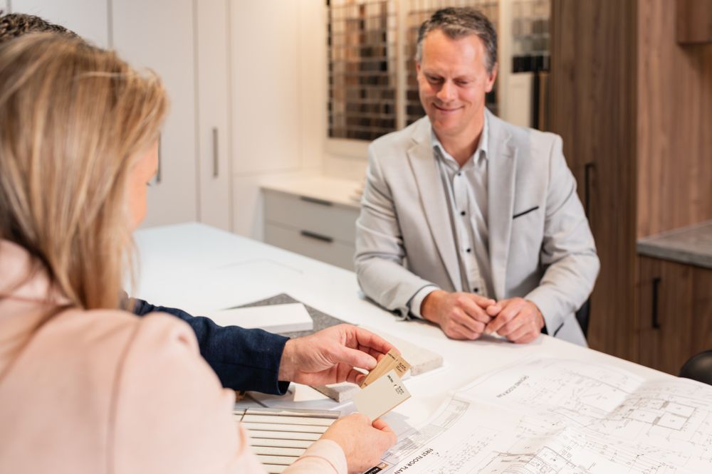 Team members collaborating over building plans in a modern office setting.