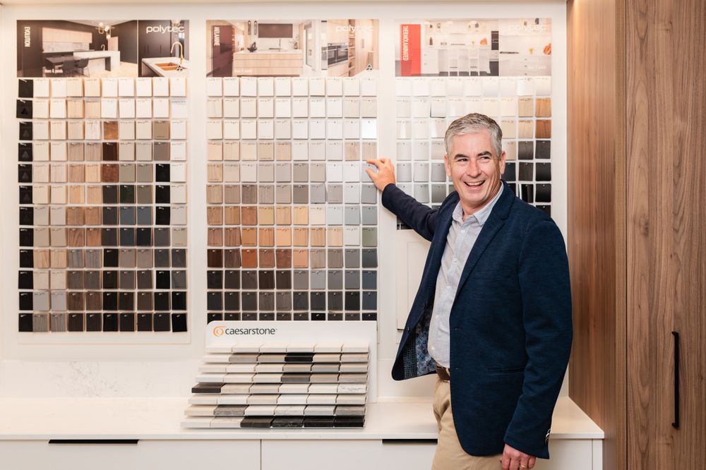 Design studio workspace with tile samples and material swatches mounted on display wall.