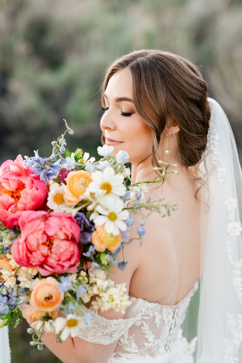Beautiful bridal portrait series featuring a colorful spring bouquet with coral peonies, daisies and delicate lace veil details.