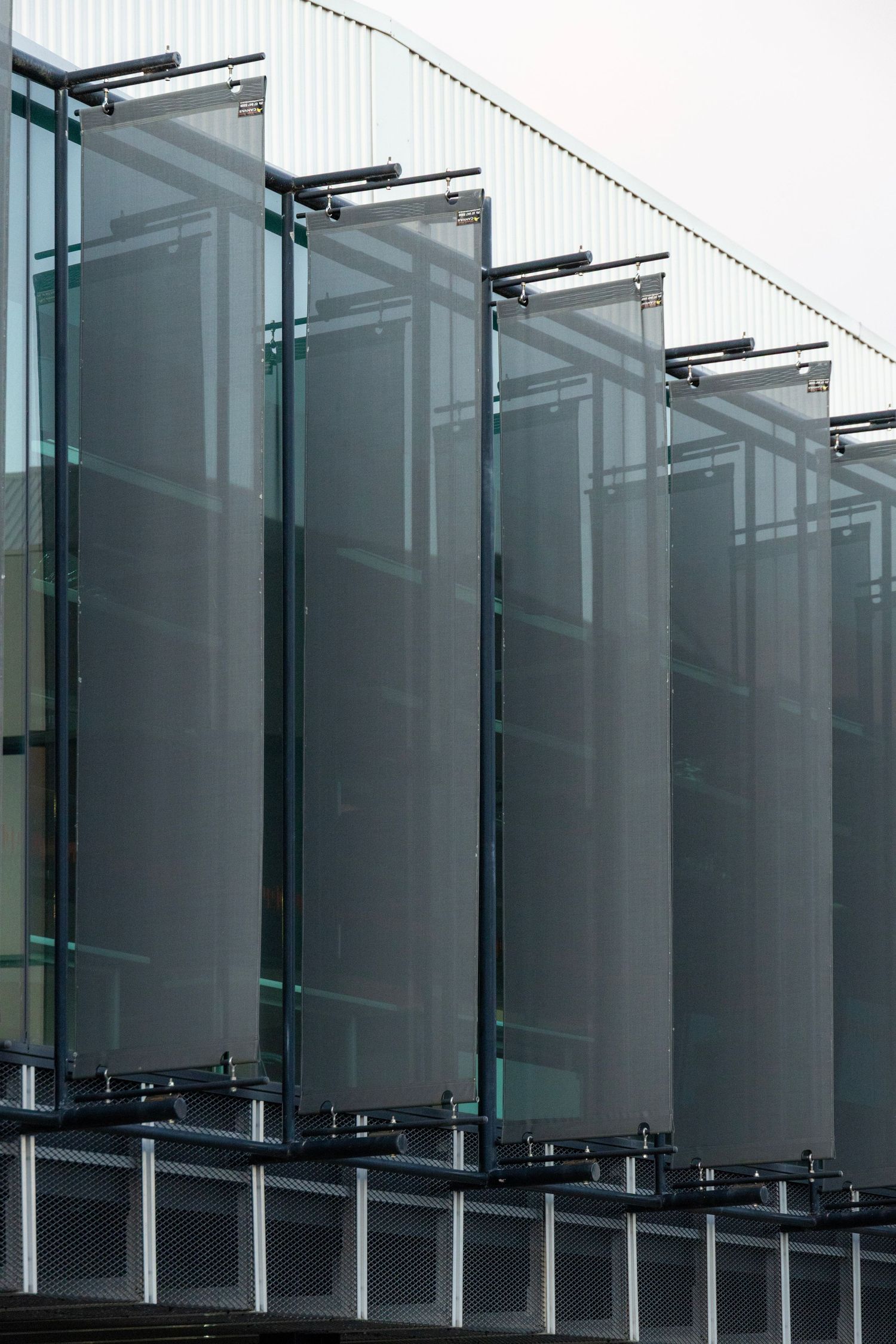 Architectural facade with vertical fabric fins casting soft shadows.
