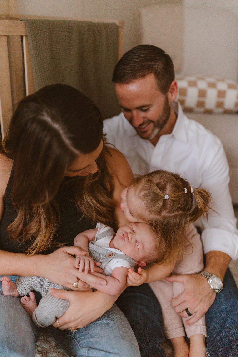 A loving family shares a tender moment together while snuggling on a couch at home.