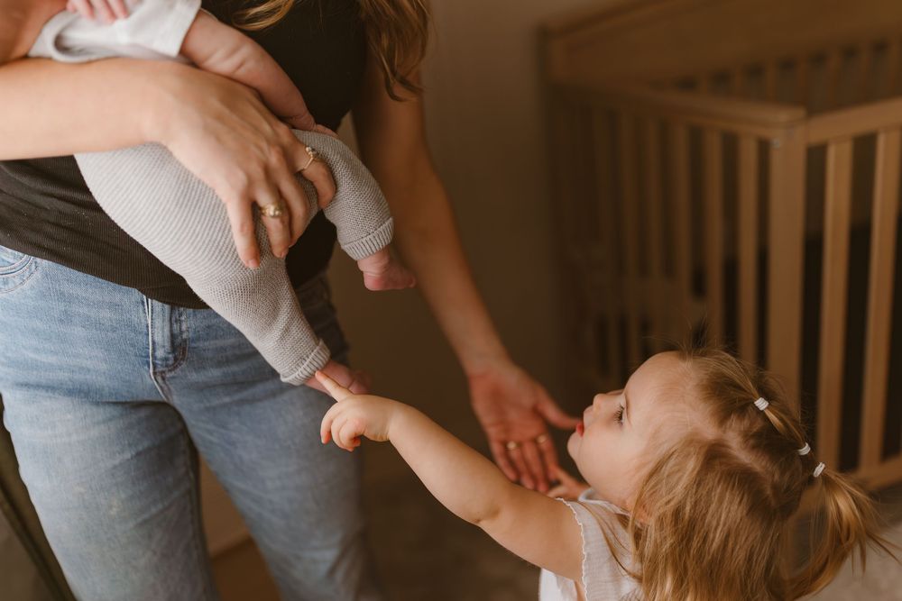 Sweet candid moments captured between a parent and child in soft lighting against a white backdrop.