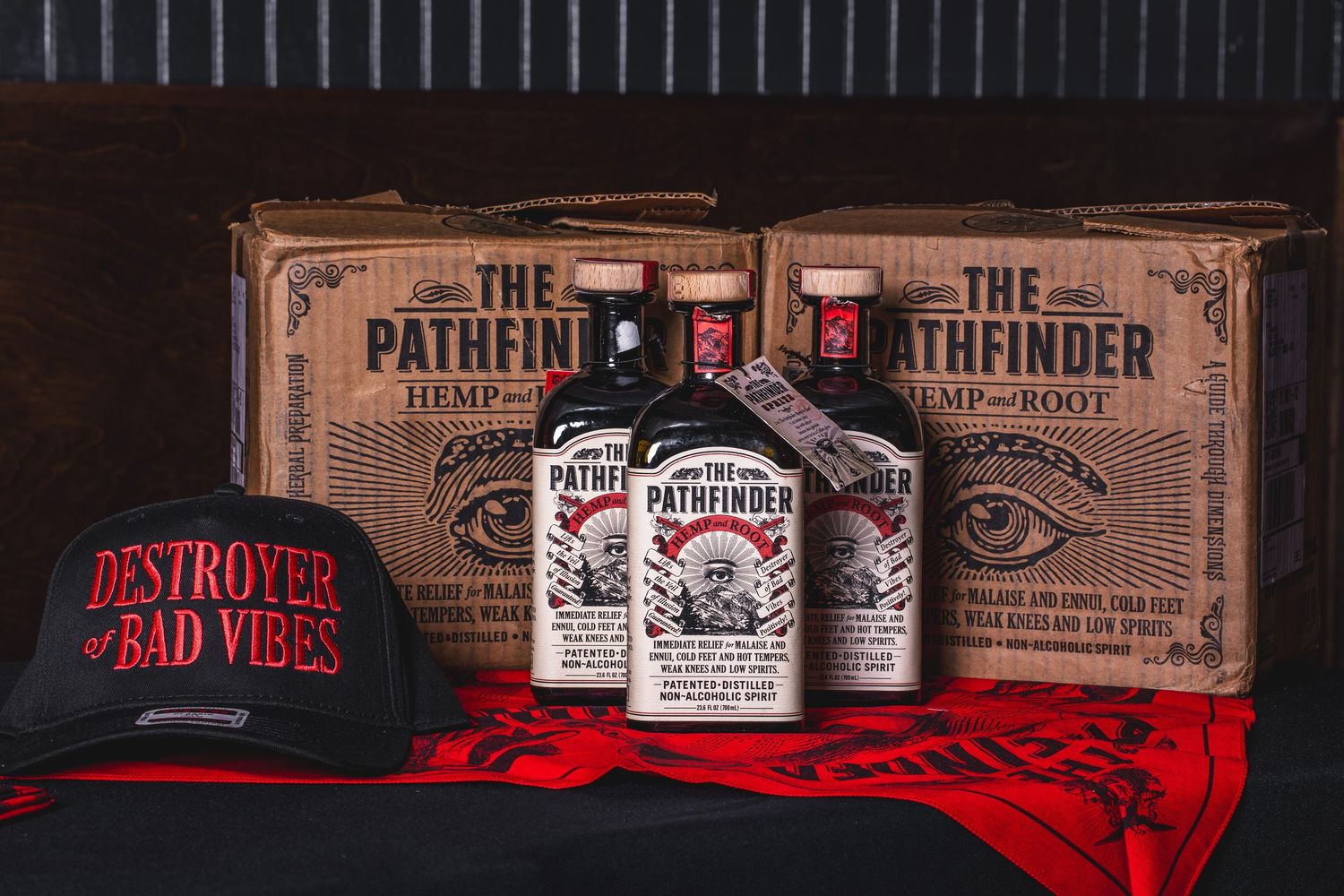 Collection of vintage-style liquor bottles displayed on rustic wooden shelf with red accent lighting.