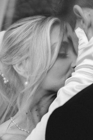 A tender romantic moment captured in black and white as a couple shares an intimate kiss.