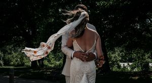 Artistic wedding photo showing couple from behind with flowing dress and shoes in motion.