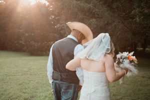 A romantic sunset wedding scene with a couple embracing in a scenic outdoor setting.