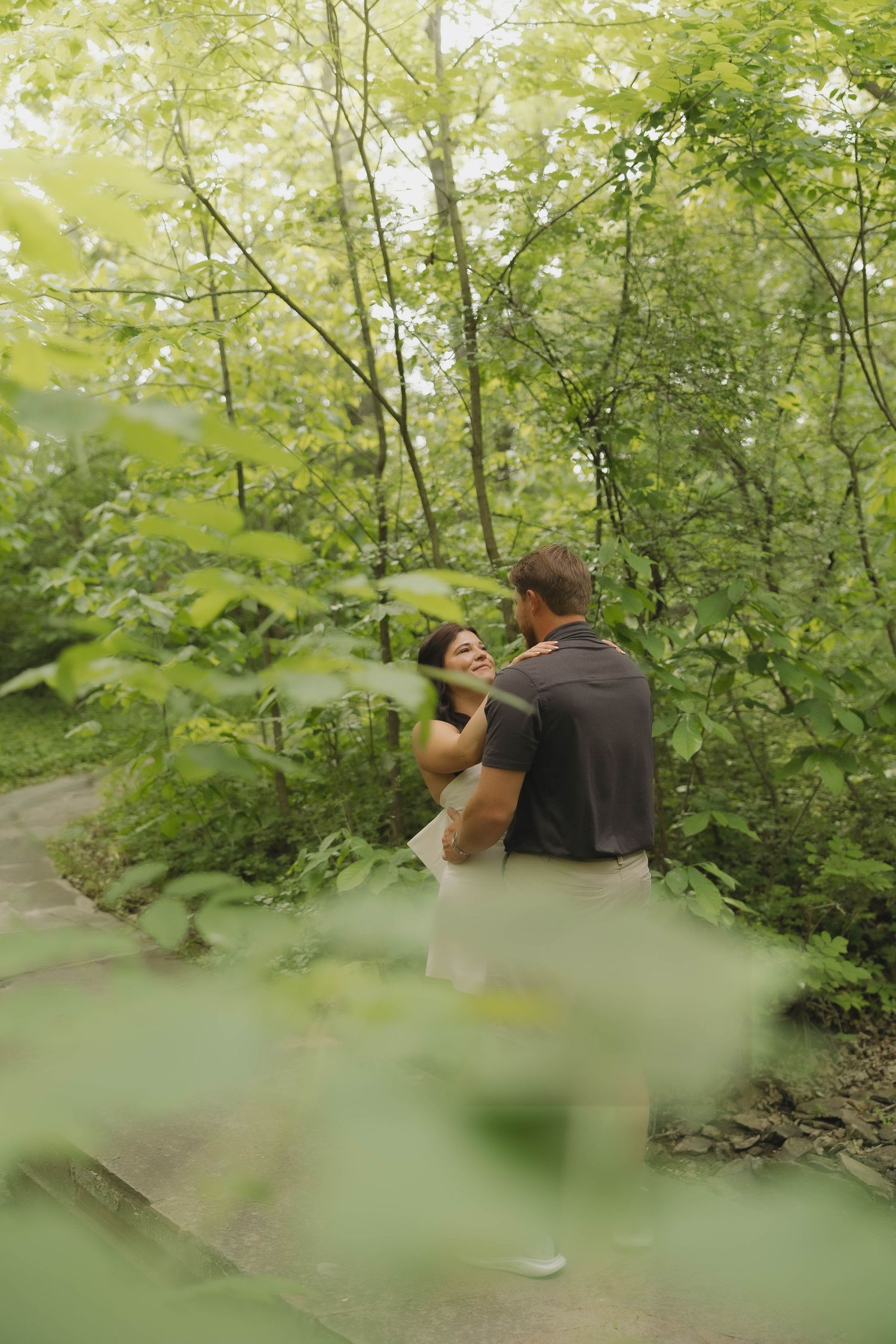 Photographer captures wildlife photos in lush green forest setting while crouching behind foliage.