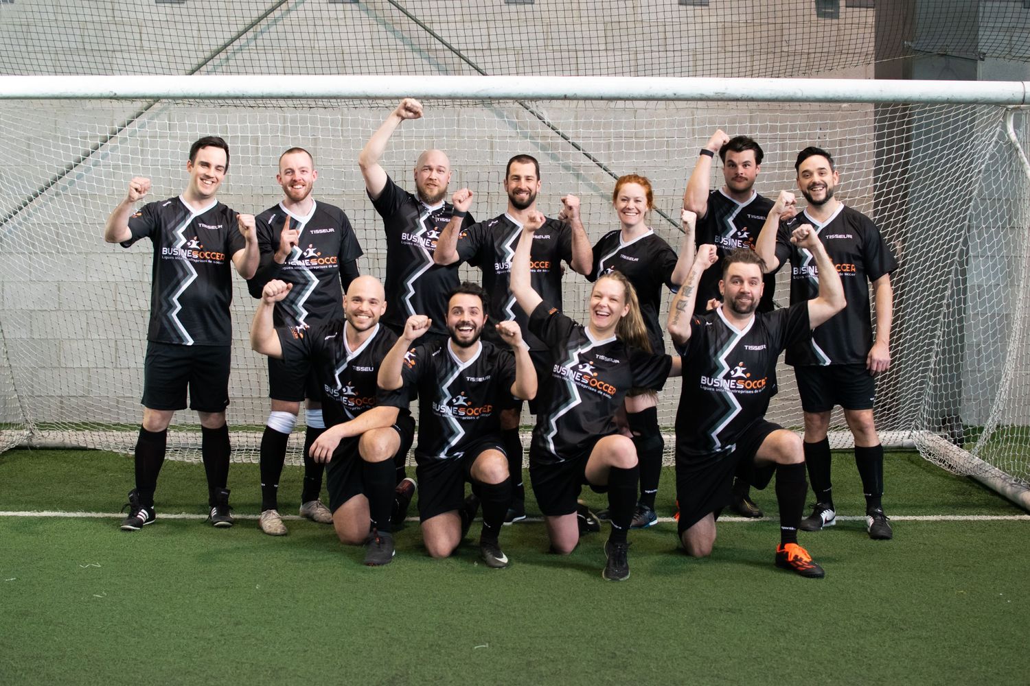 Photo d'une équipe de soccer posant ensemble sur le terrain, tous les joueurs sont alignés, portant leurs maillots d'équipe.
