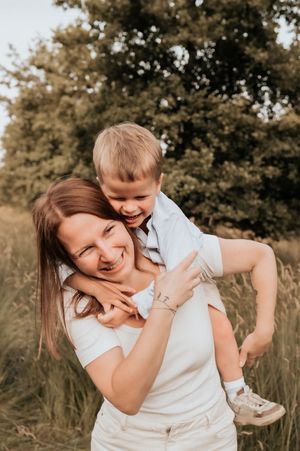 mommy and me momentje tussen moeder en zoon tussen de hoge grassen tijdens een golden hour shoot in Roeselare
