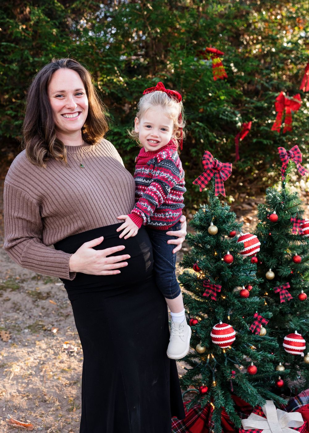 A festive holiday scene with a decorated Christmas tree and a cozy winter sweater by a bush with red berries.