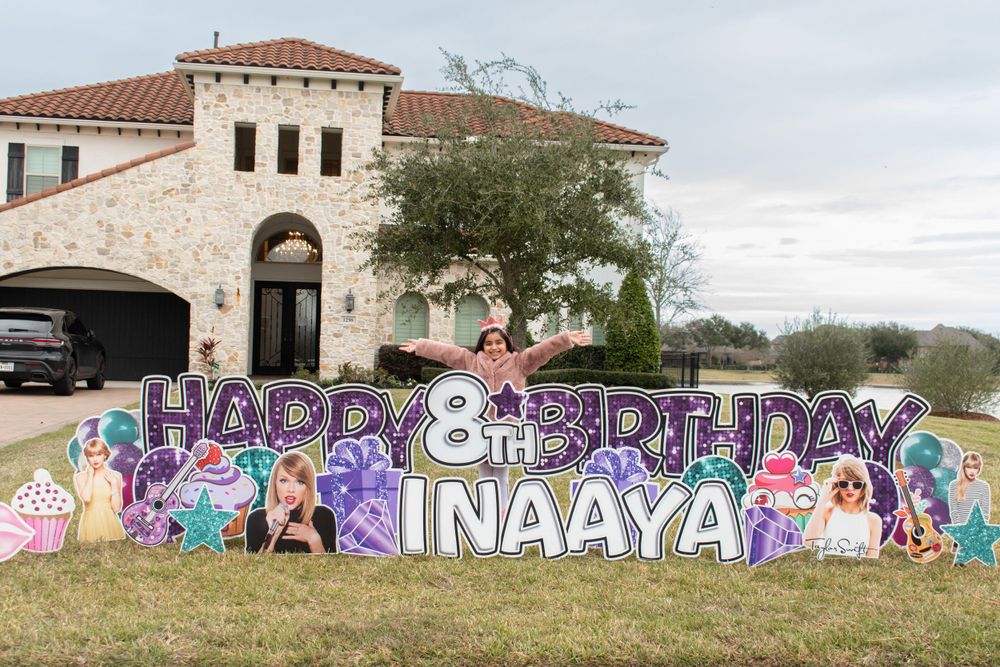 Colorful yard sign display reading Happy 8th Birthday with princess characters in front of a stone house.