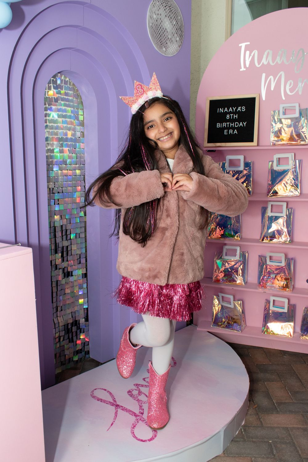 Celebration scene with purple archway and pink decor in a party setting.