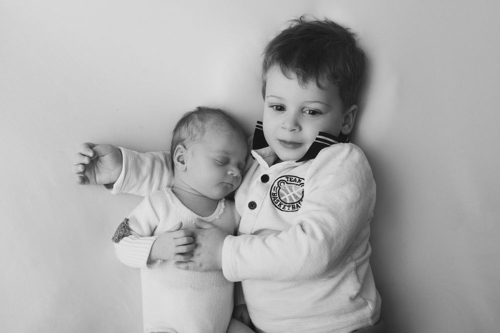 Portrait noir et blanc d'une fratrie avec nouveau-né à Fléac.
