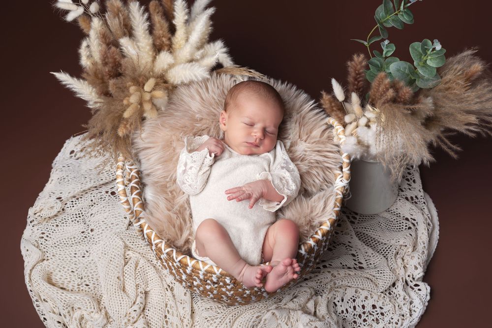 Nouveau-né endormi dans un panier en osier lors d'une séance photo naissance réalisée par Studio Nath à Fléac près d'Angoulême en Charente.