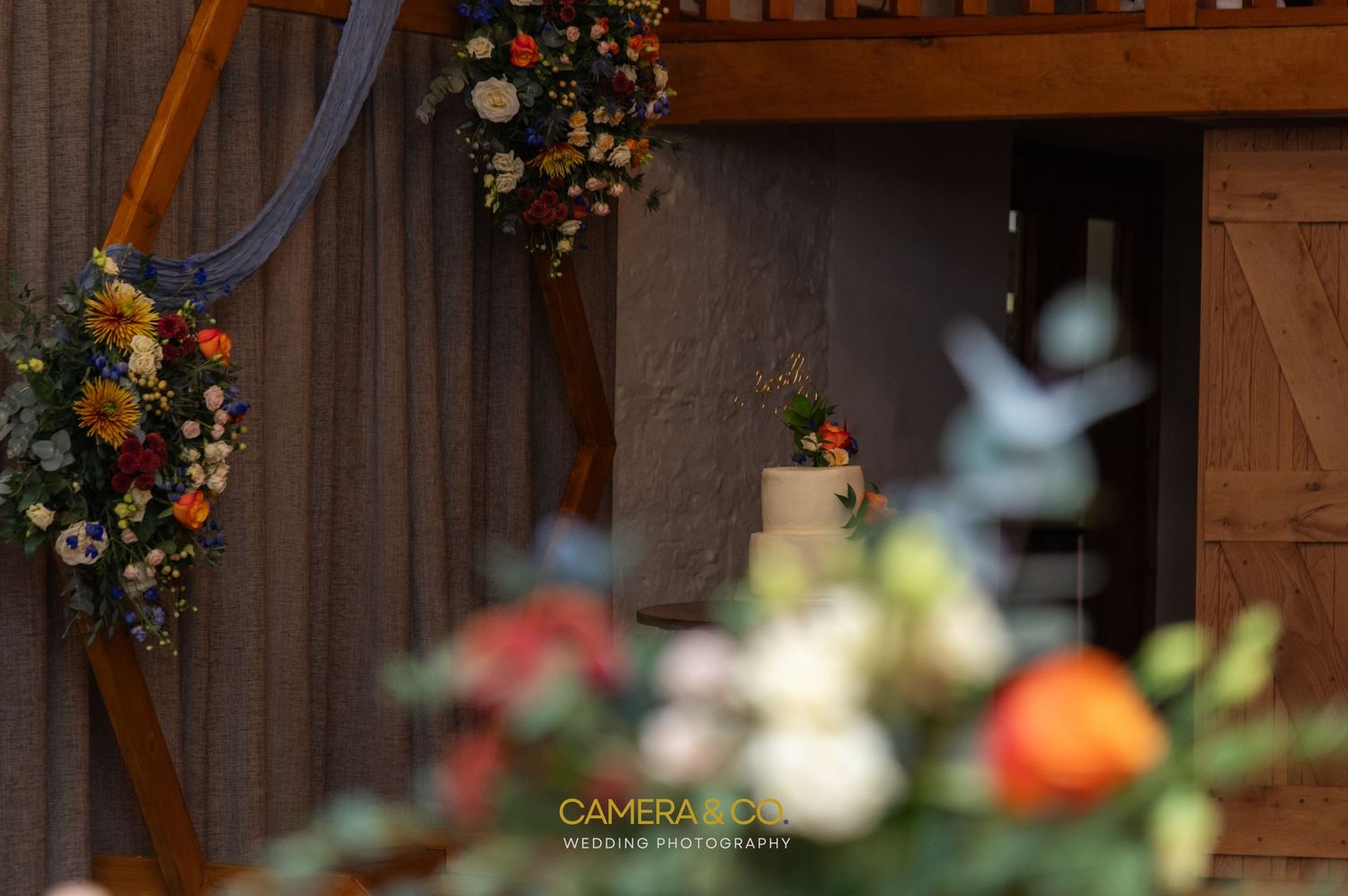 Rustic barn wedding venue decorated with colorful floral arrangements.