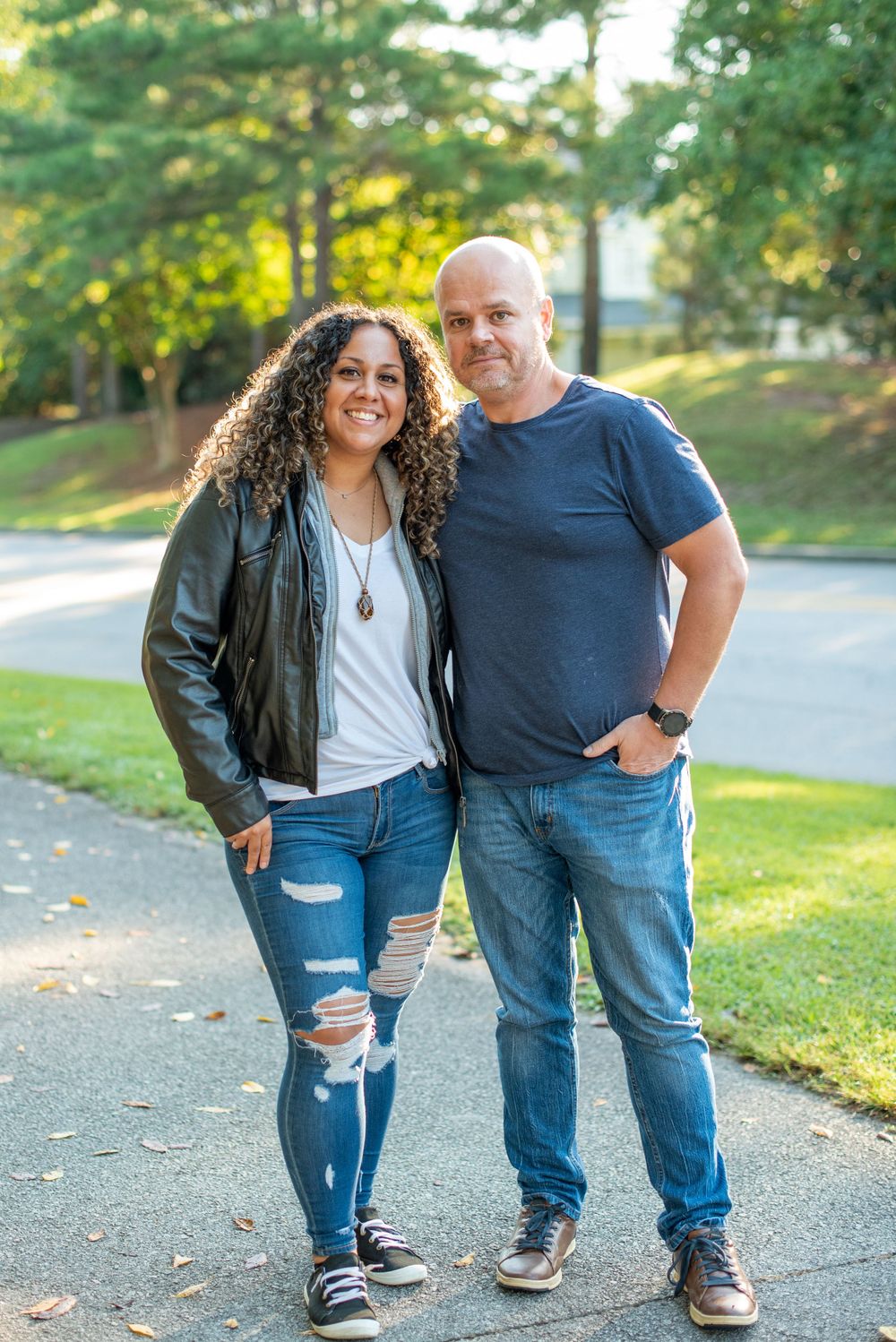 Two people walking together on a tree-lined path during golden hour during their business branding session in columbia, sc.