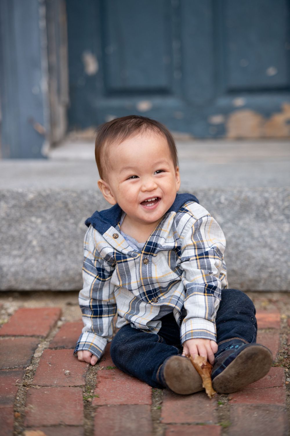 A series of photos showing a small child in plaid shirt crawling and smiling on brick pavement.