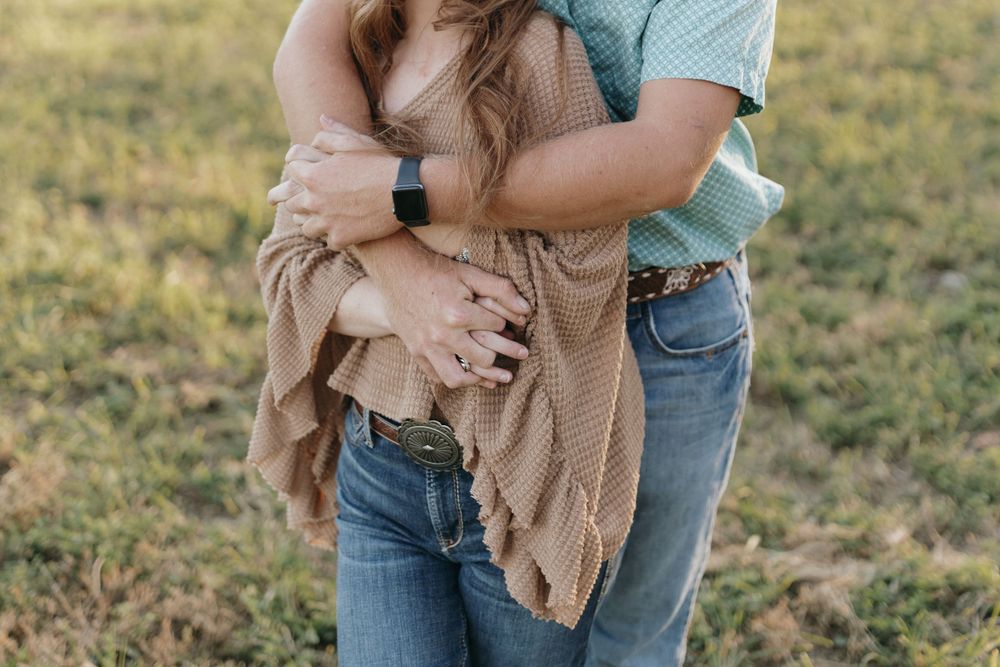 Close-up shot of a couple embracing, wearing casual denim and knit sweater.