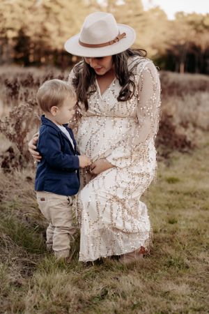 Rustic outdoor family maternity photos featuring lace dress and earth-toned clothing.