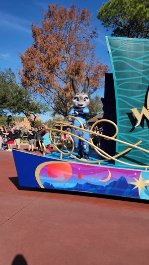 A colorful parade float featuring the animated character Judy Hopps from Zootopia against a bright blue sky with autumn trees.
