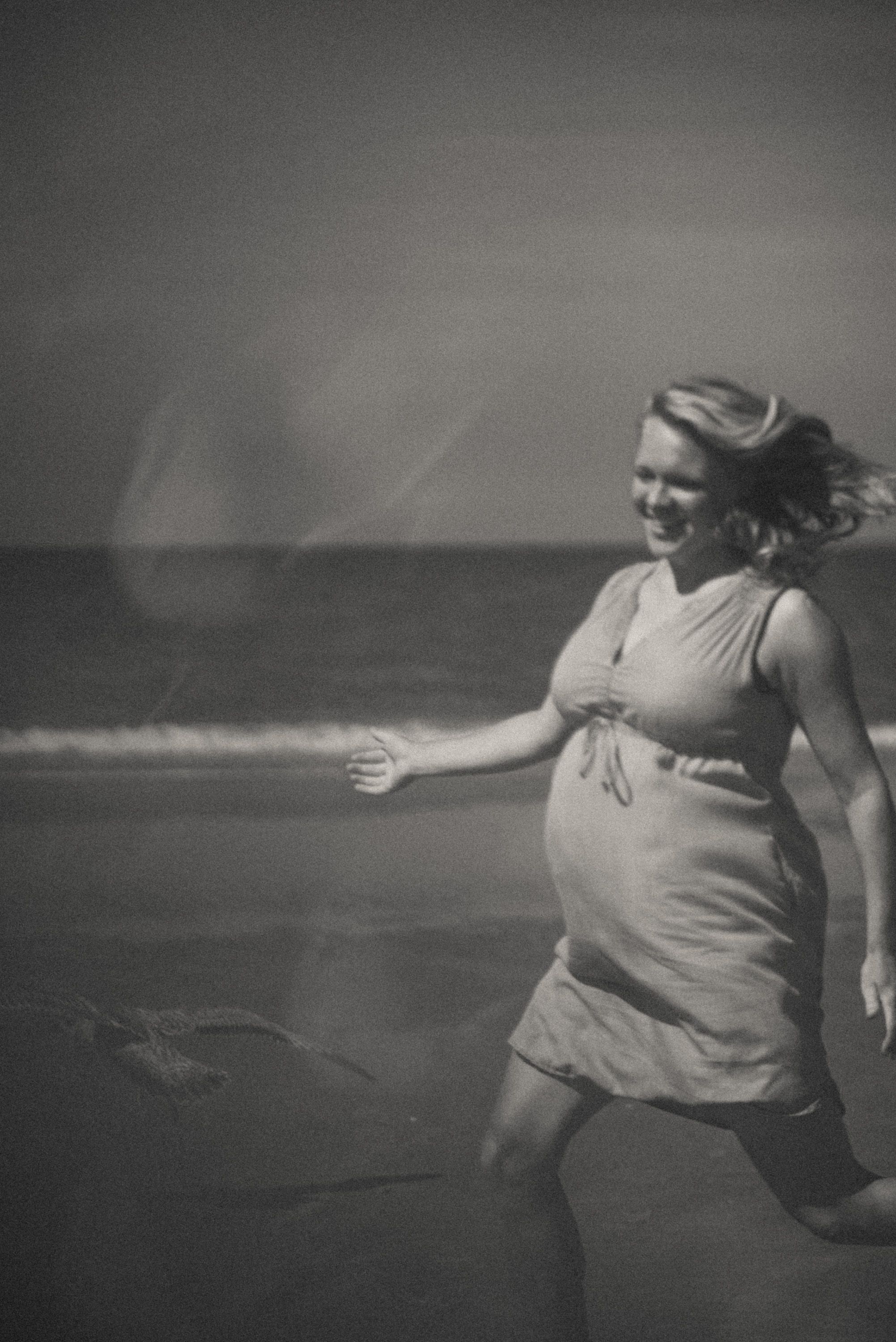 Black and white artistic sequence showing a person dancing on a beach in flowing motion.