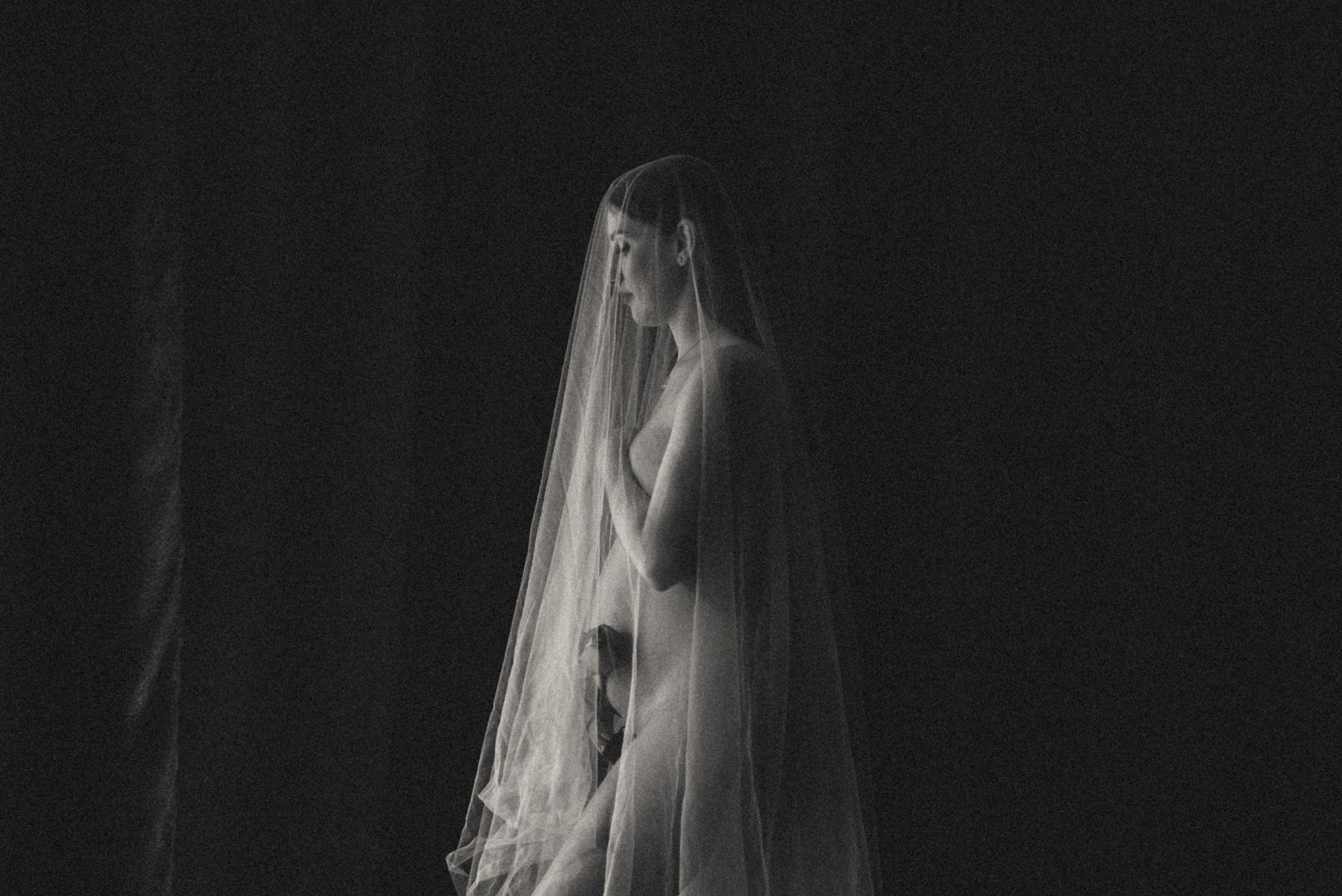 Dramatic silhouette series with sheer fabric creating ethereal movement in dark lighting.