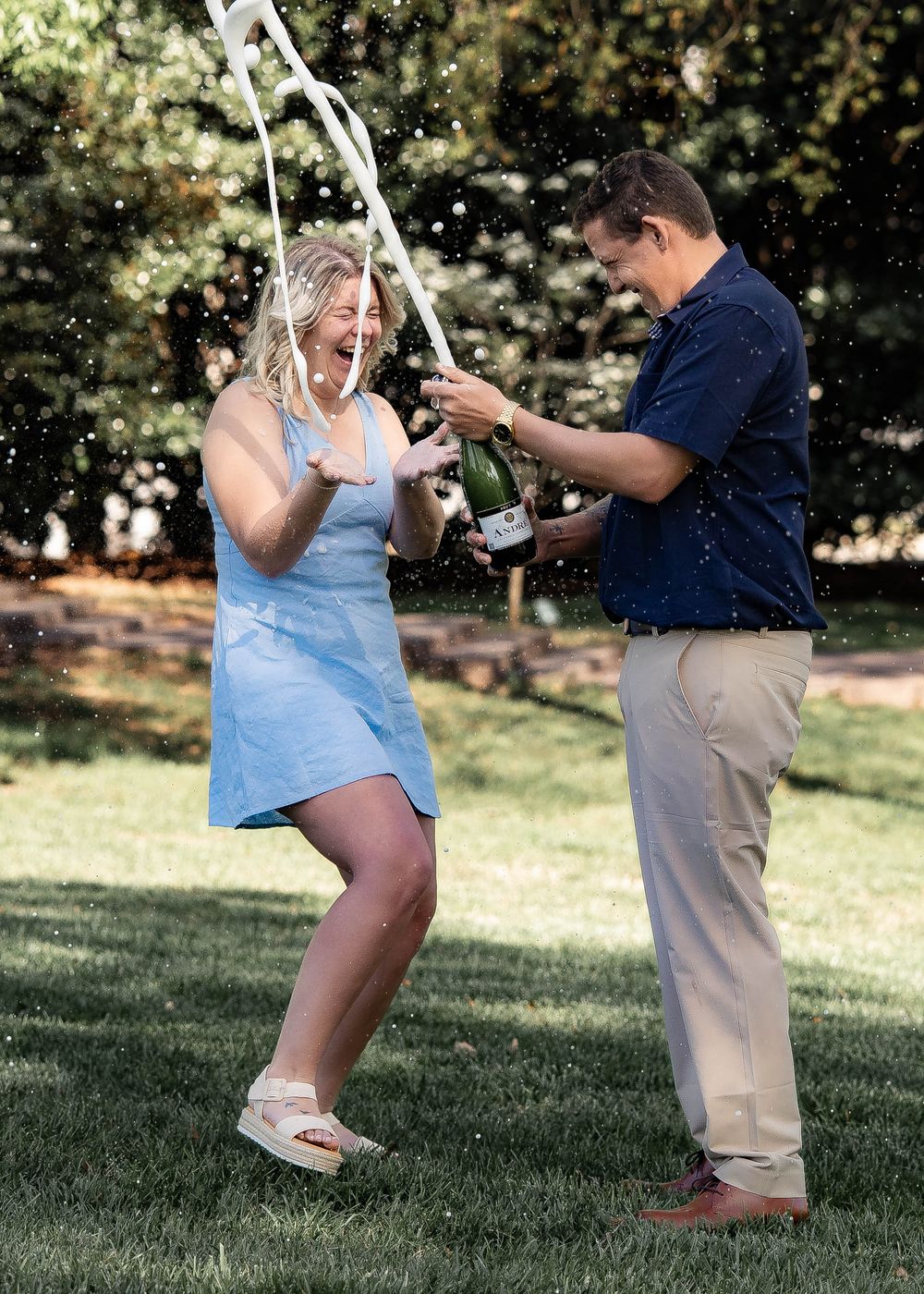 A couple playfully pops and catches confetti in multiple progression shots on a sunny lawn.