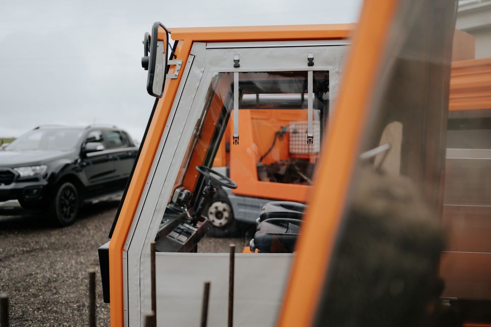 Baustelle mit orangefarbenen Absperrungen und Warnschildern entlang einer Straße.