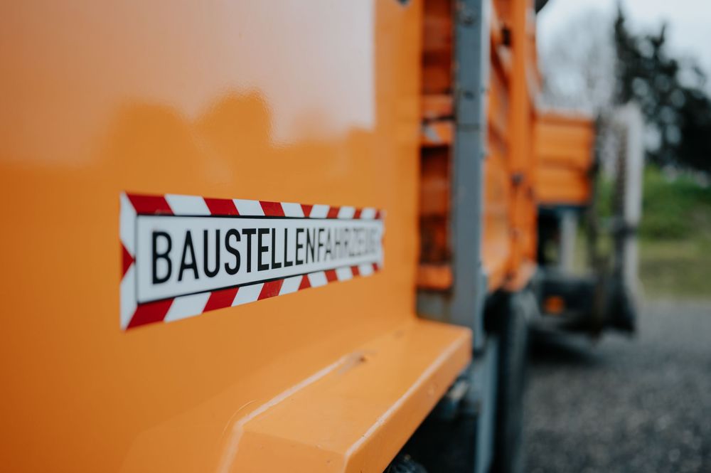 Baustelle mit orangefarbenen Absperrungen und Warnschildern entlang einer Straße.