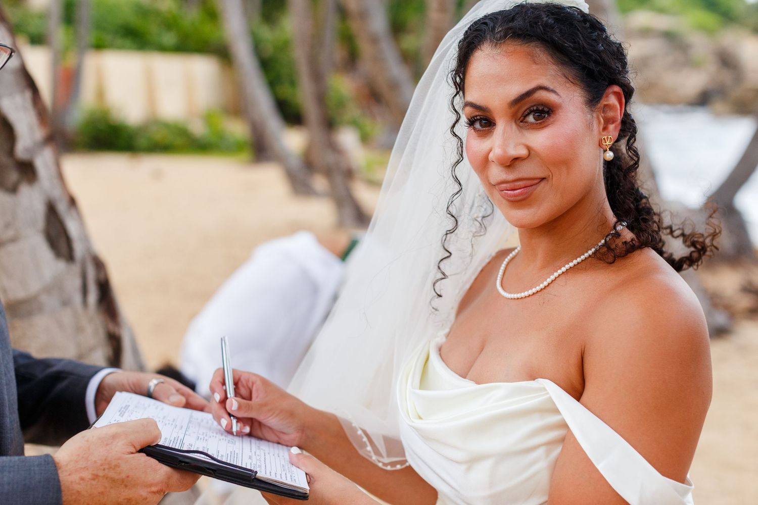 Bride signing marriage license. Intimate beach wedding in Palmas del Mar, Puerto Rico.