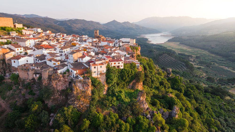 Panoramic view of a hillside village in Portugal overlooking the Douro Valley with terraced vineyards and mountains.