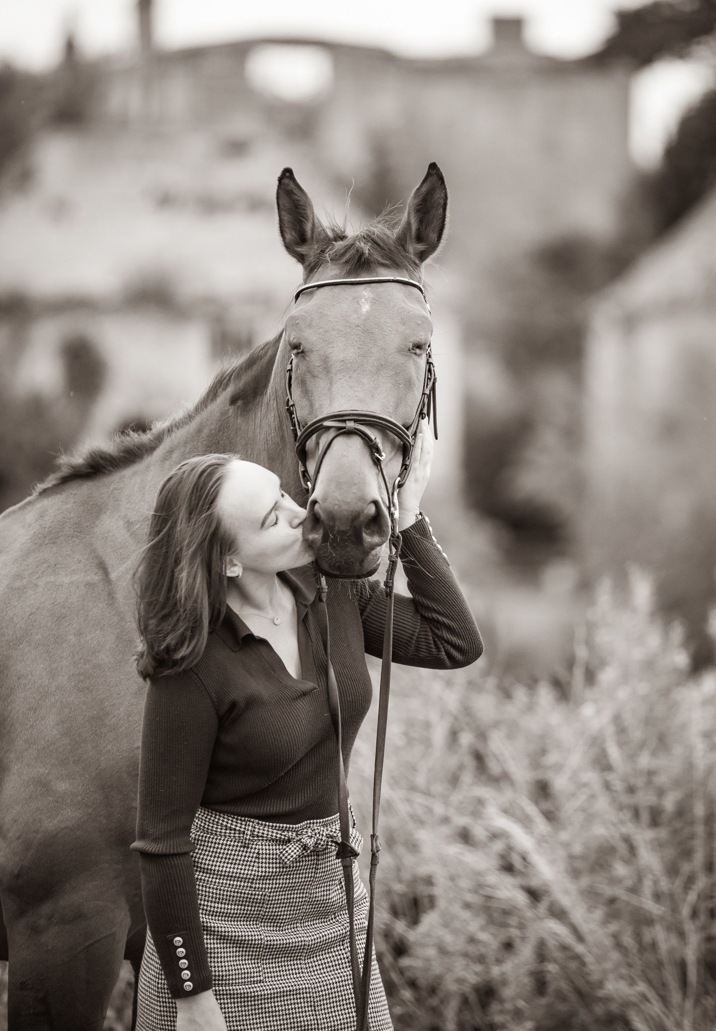 A beautiful black and white paint horse stands with a person on a sunny autumn day outdoors.