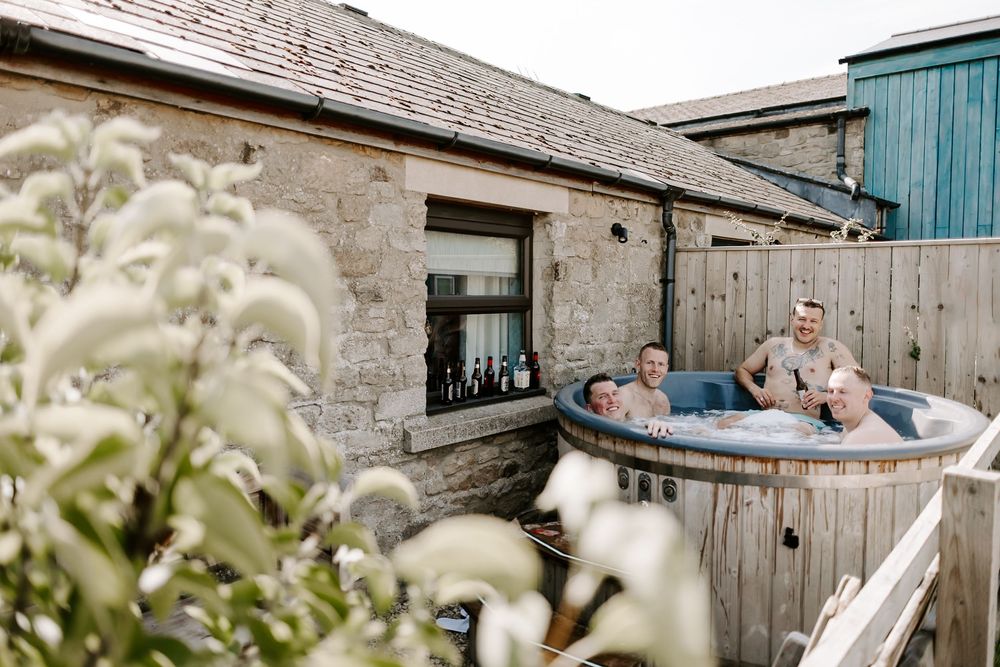 A sequence of photos showing people relaxing and enjoying a tranquil outdoor hot tub against a rustic stone wall setting.
