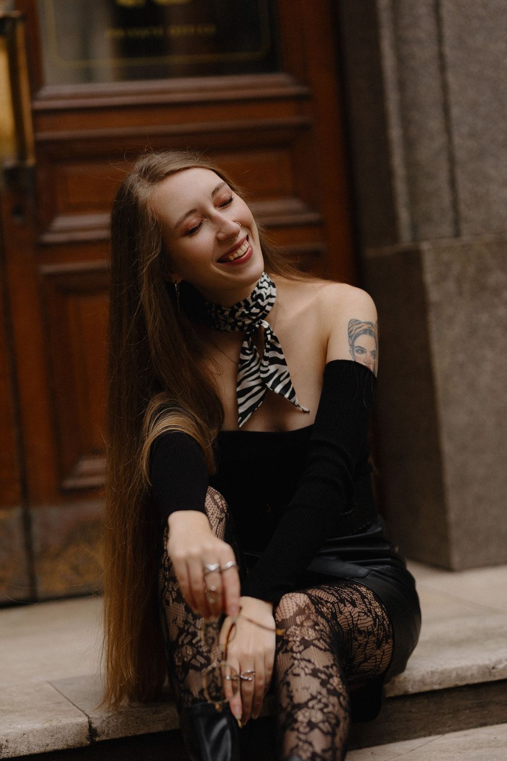 Artistic portrait series featuring a model in black lace dress sitting on stone steps with vintage architecture.
