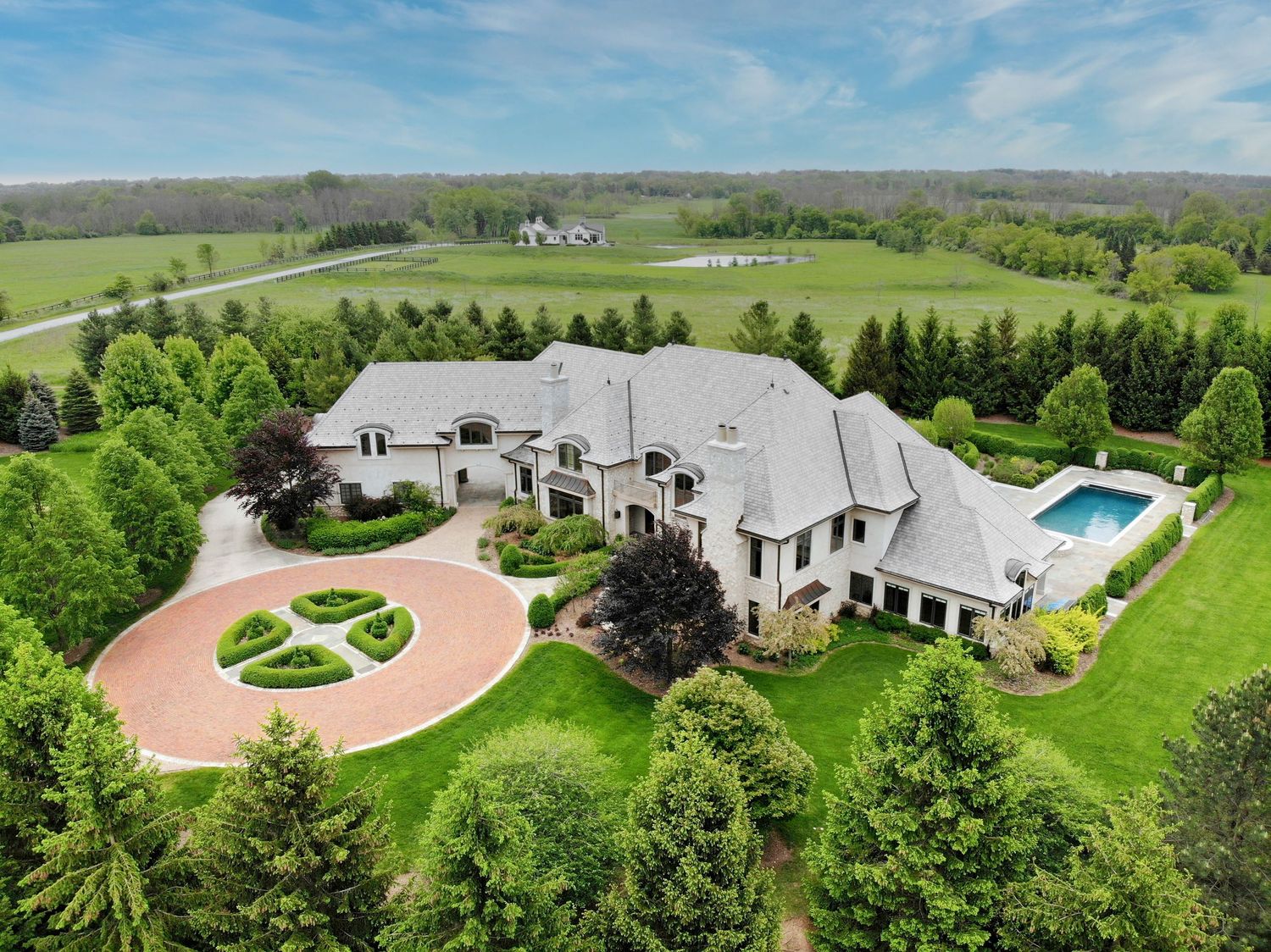 Aerial drone photo of a luxury estate with circular driveway and pool, Wisconsin