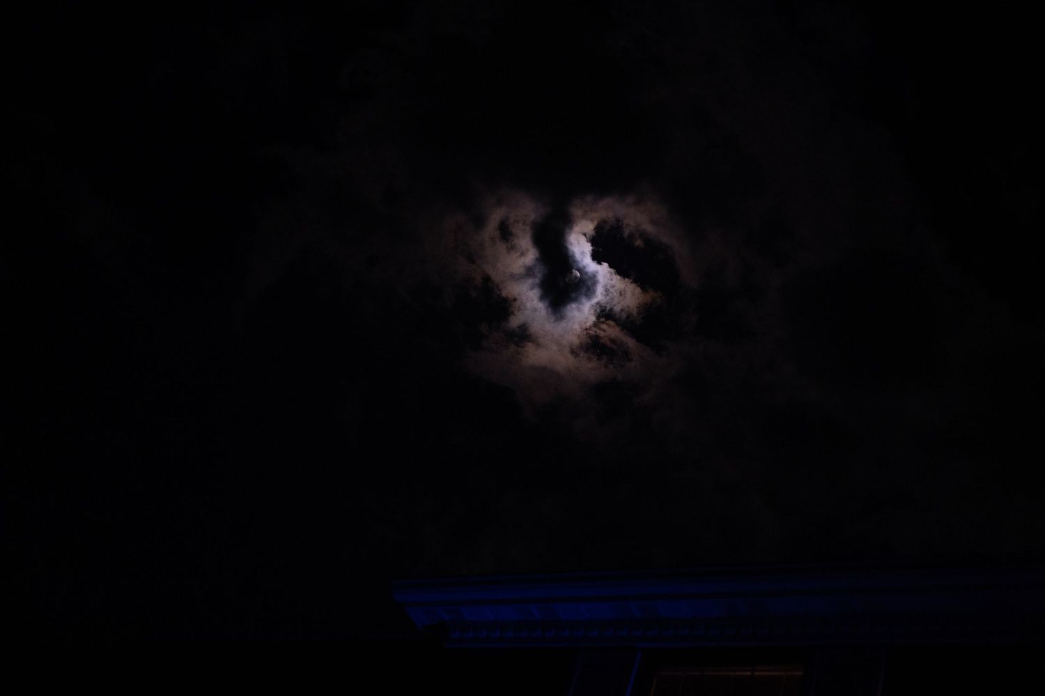 A series of dark silhouettes against a night sky with glowing lights and stars creating a dramatic atmospheric scene.