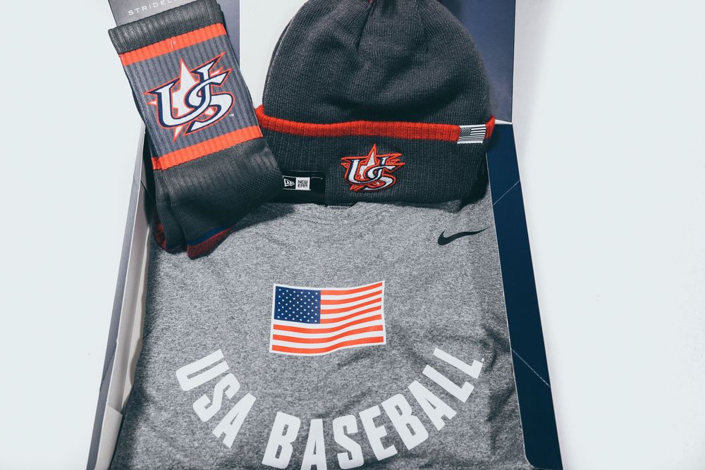 Gray USA Baseball Nike hoodie with American flag patch, beanie, and socks in box.