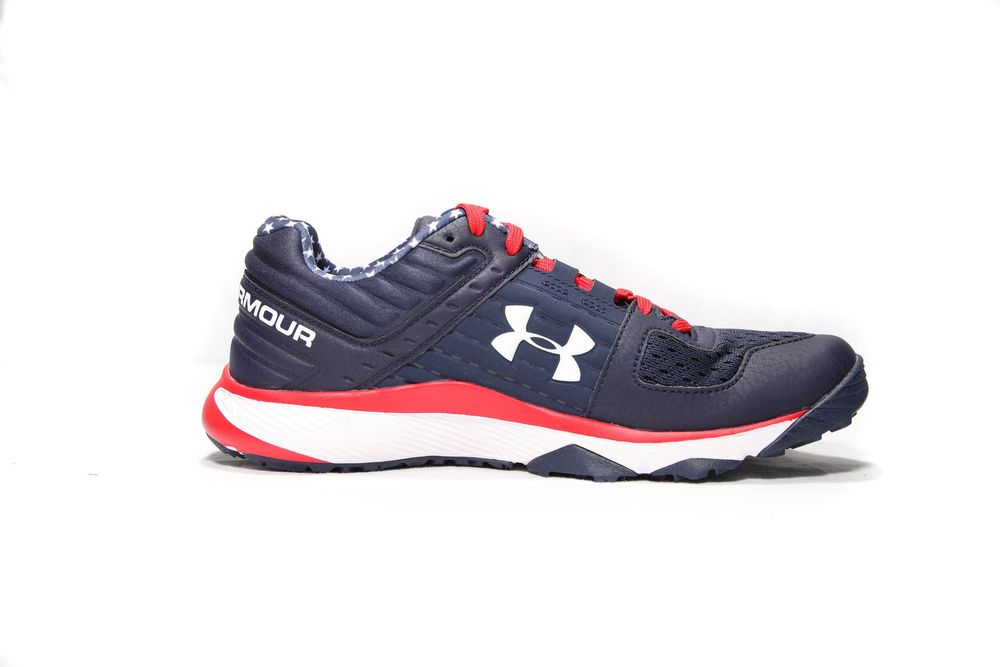 Under Armour navy blue and red baseball training shoe with white logo on side profile view.