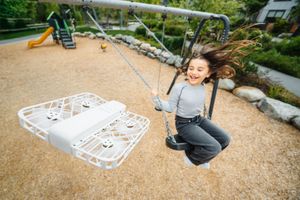 A sequence showing someone creating a large hopscotch pattern with white chalk on a playground surface.