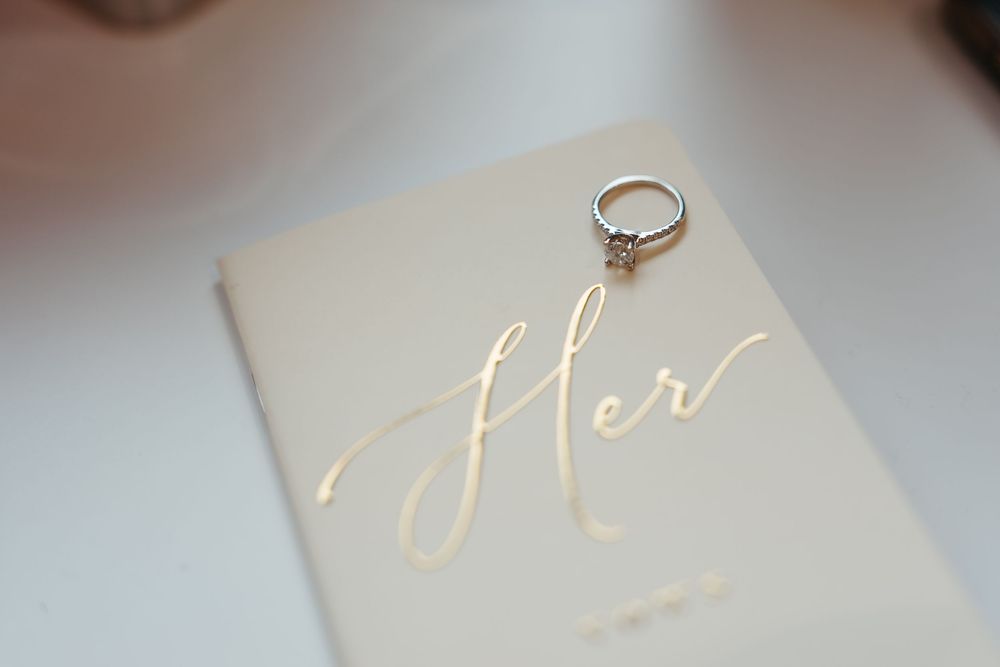 Close-up view of gold foil lettering on a white surface showing elegant calligraphy text.