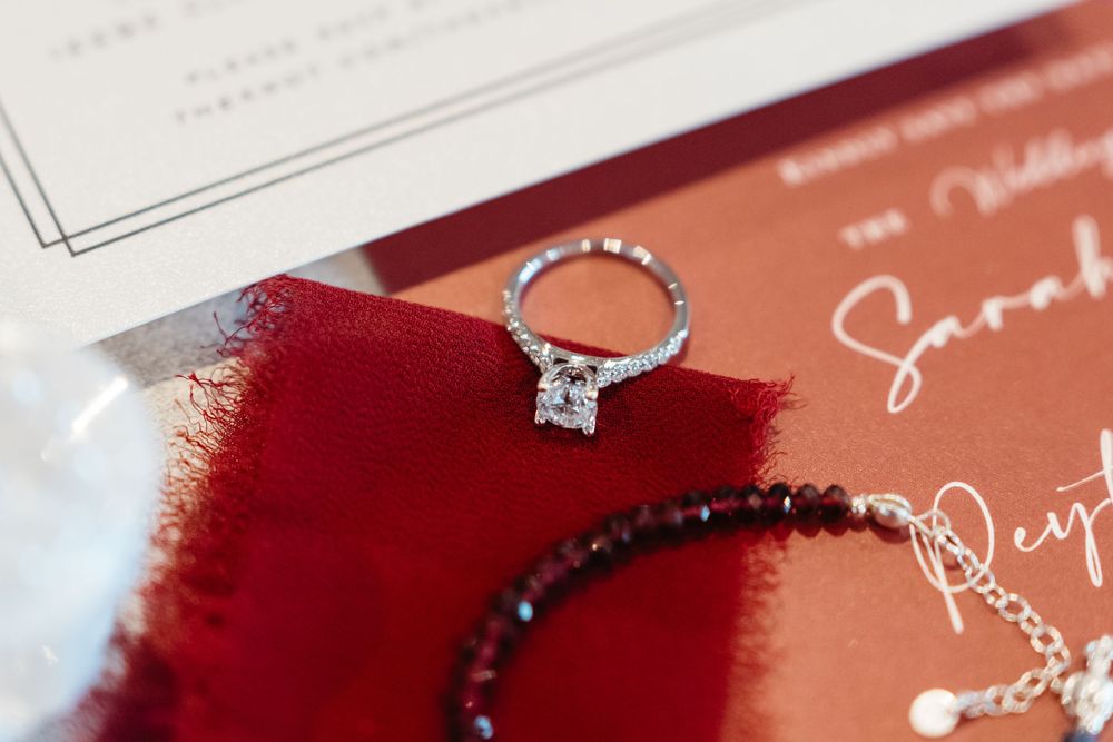 Elegant red wedding invitations and calligraphy supplies arranged on a light surface.