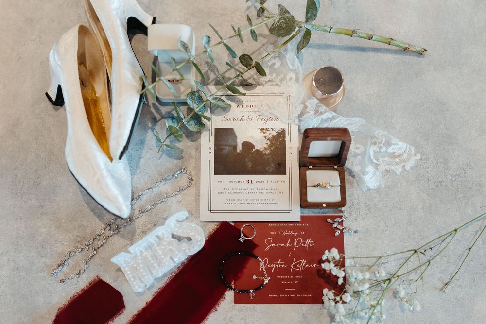 Wedding stationery and floral decorations artfully arranged on a textured gray background.