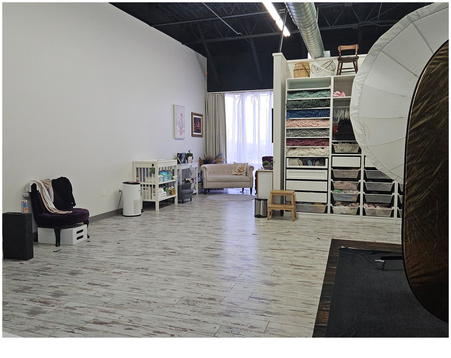 Wide image of Valerie Kay Photography Studio room from back of room towards the front of the room showing the cream settee.