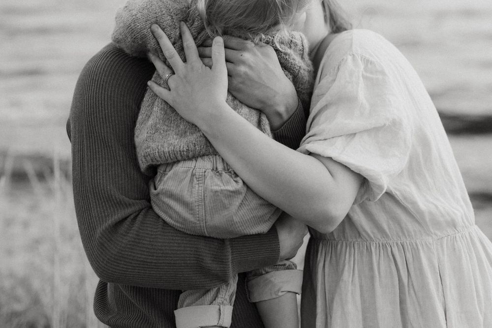 A series of black and white romantic photographs showing a couple embracing in an outdoor setting.