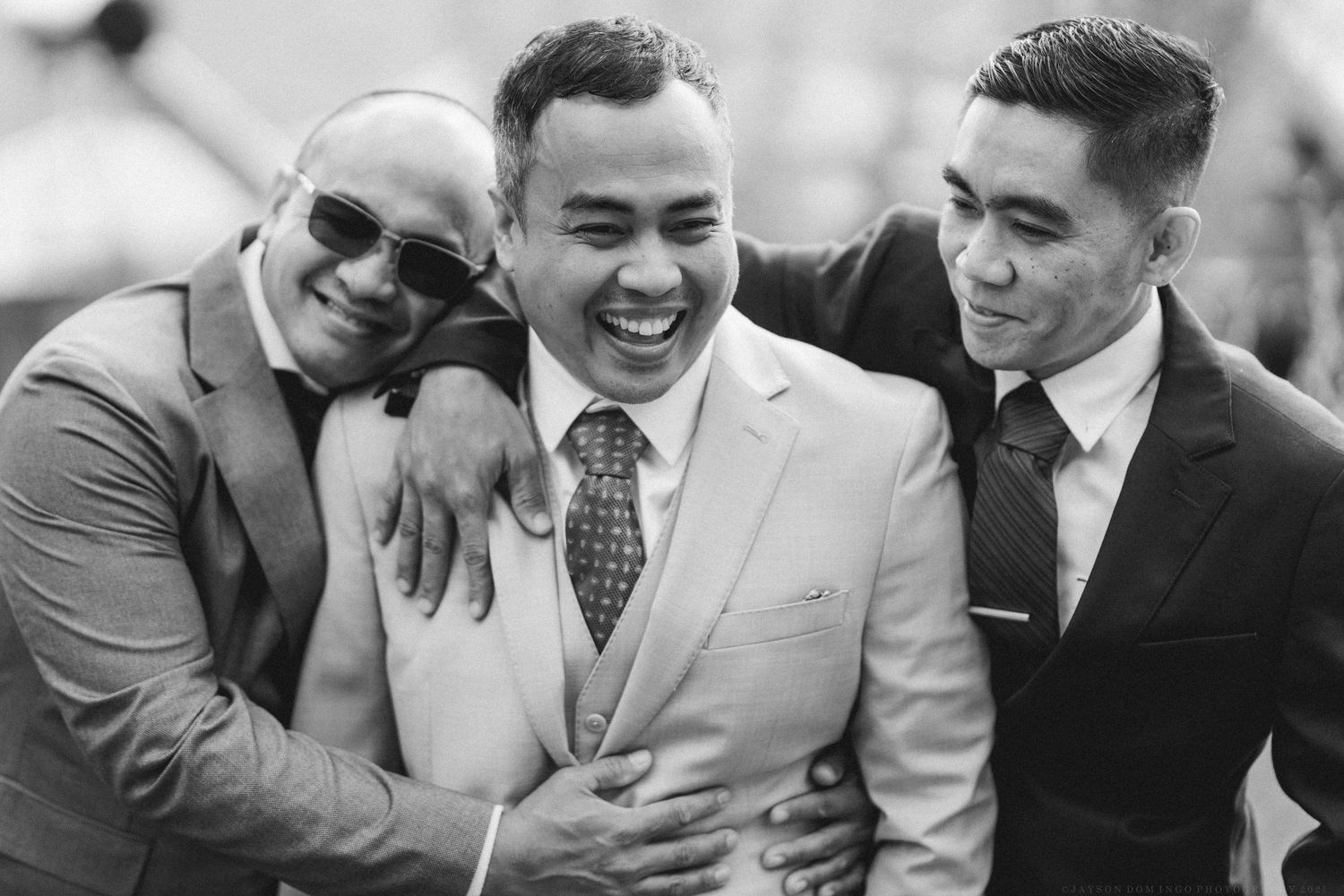 Black and white portraits of groomsmen laughing and embracing.