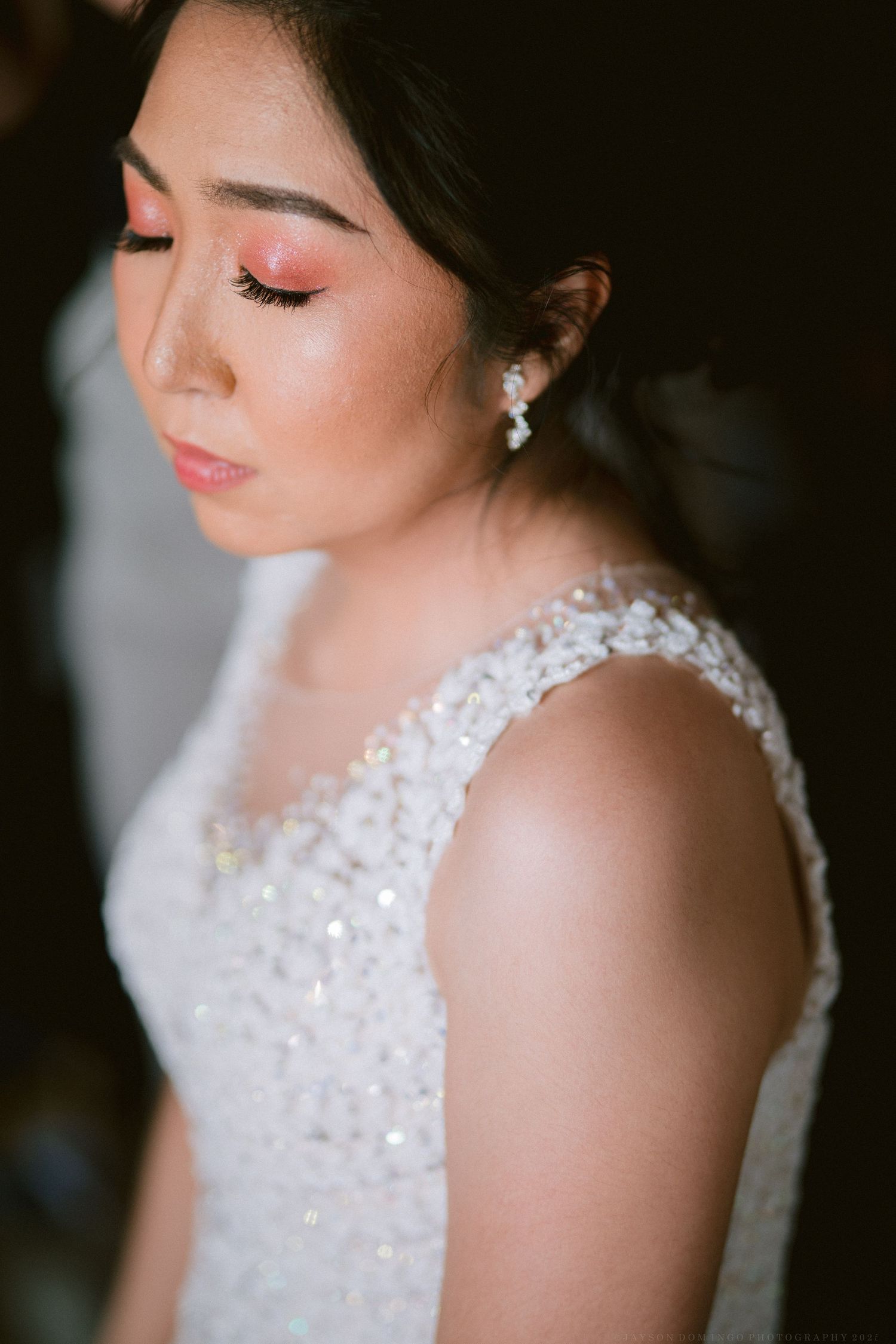 Close-up details of sparkling beadwork on a white wedding dress.